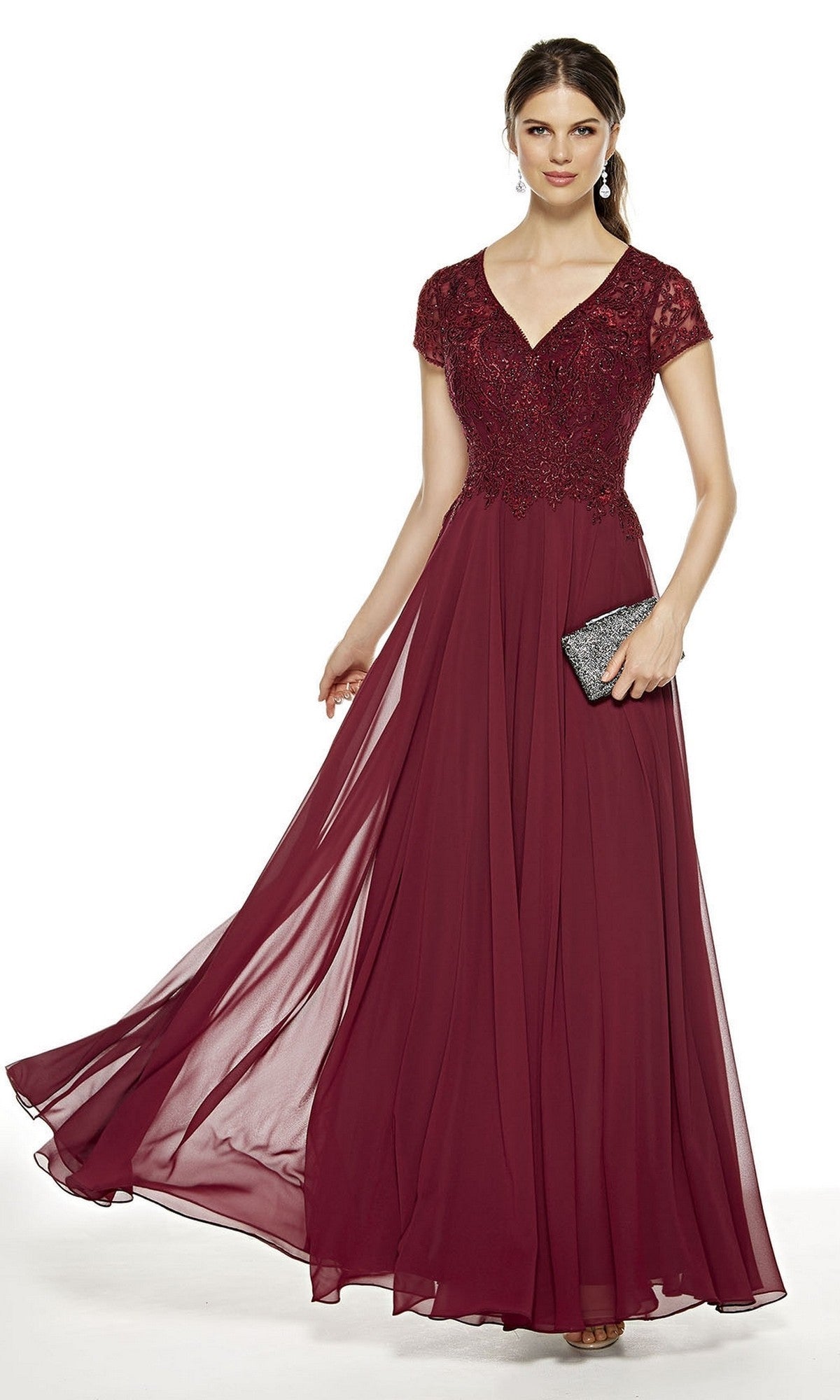A woman stands against a white background wearing the Alyce 27389 long burgundy formal dress featuring a lace bodice, chiffon A-line skirt, and cap sleeves, holding a black clutch.